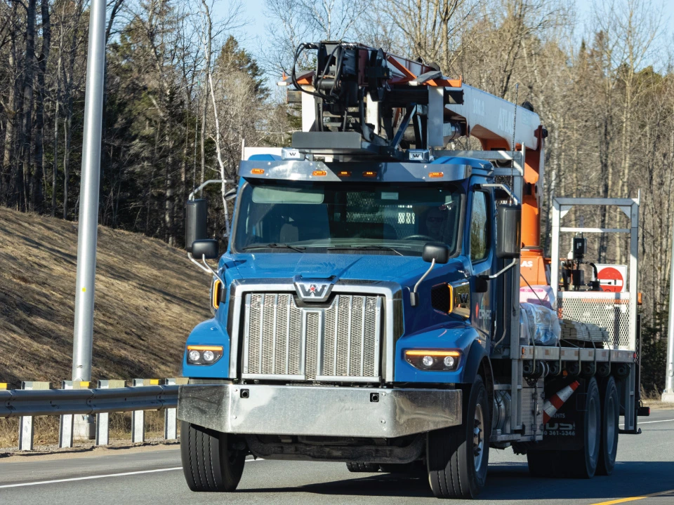 crane truck traveling down roadway with CDL licensed driver